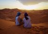 a man and woman admiring sunset in moroccan desert