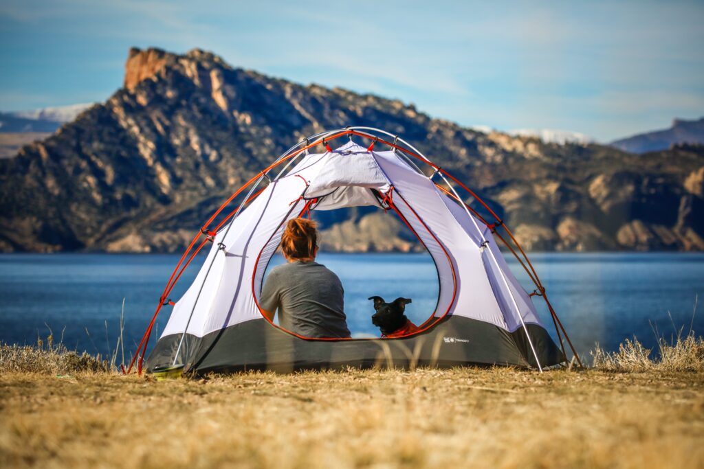 A girl and a dog inside a tent