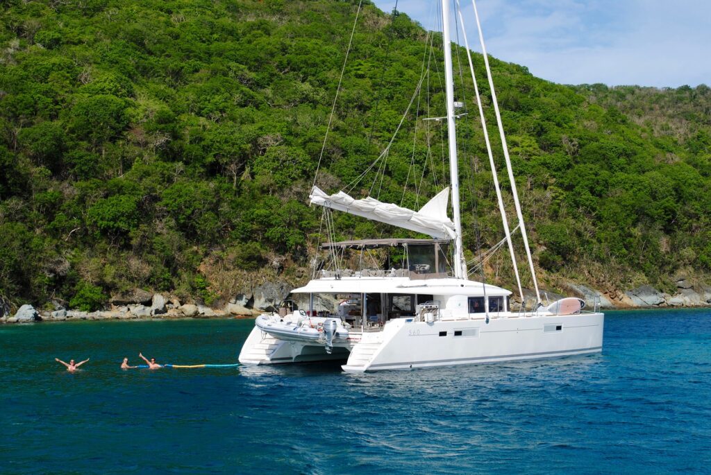 A catamaran docked in open sea in front of an islet.