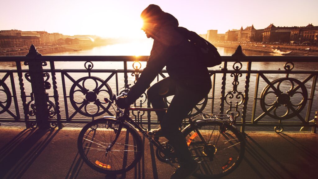 A man biking under sunset.