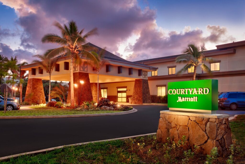 What seems to be a big house with parked cars outside and a signage that says Marriott Courtyard.