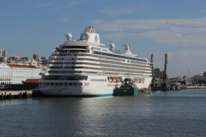 A white cruise ship docked in a harbor.