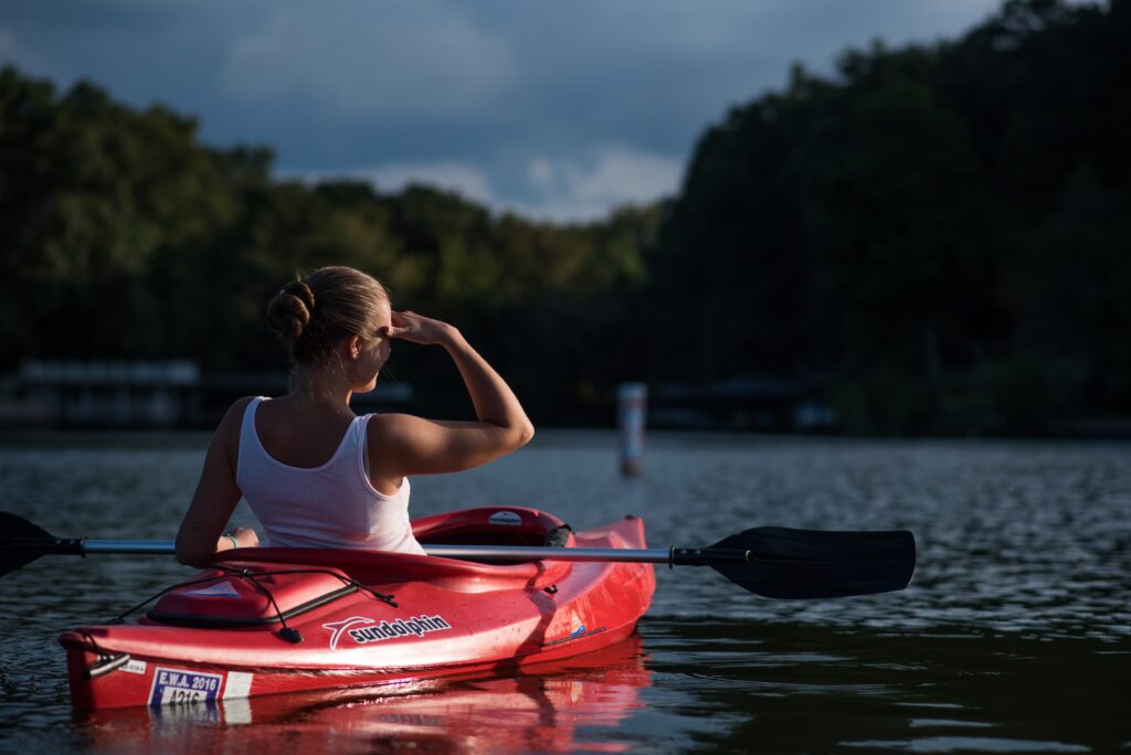 A woman riding on a kayak in an open water.