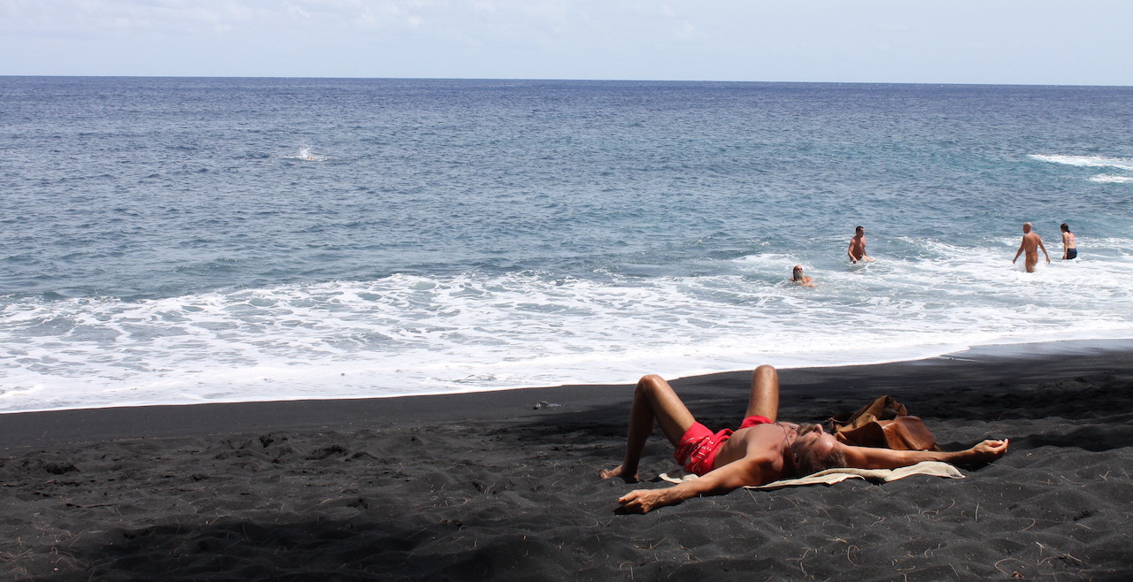 Sunbathing at Kehena Black Sand Nude Beach, Big Island in Hawaii