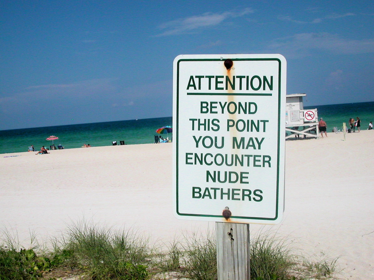 A nude beach warning sign
