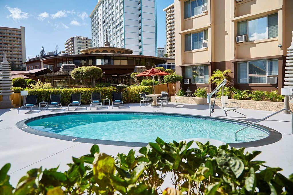 A circular swimming pool with building from behind.