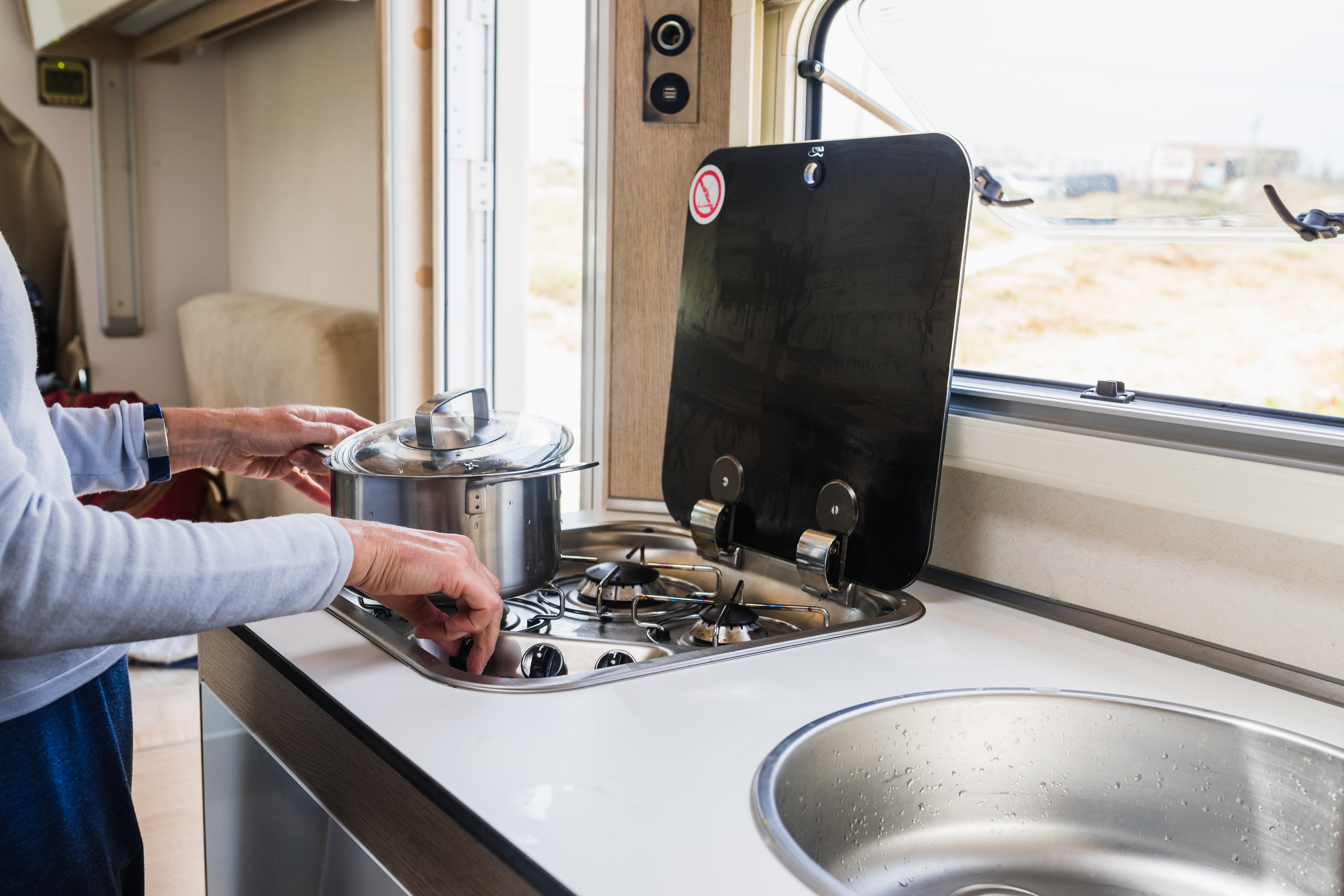 Woman cooking in a camper kitchen