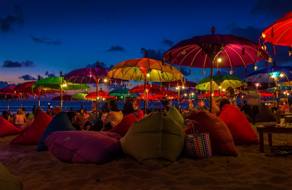 Colorful umbrellas and bean bags by the seaside during night time