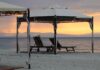 Beach Umbrella on the beach with deck chairs during sunrise