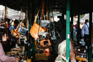 Vintage cameras and camera holders displayed in a flea market.