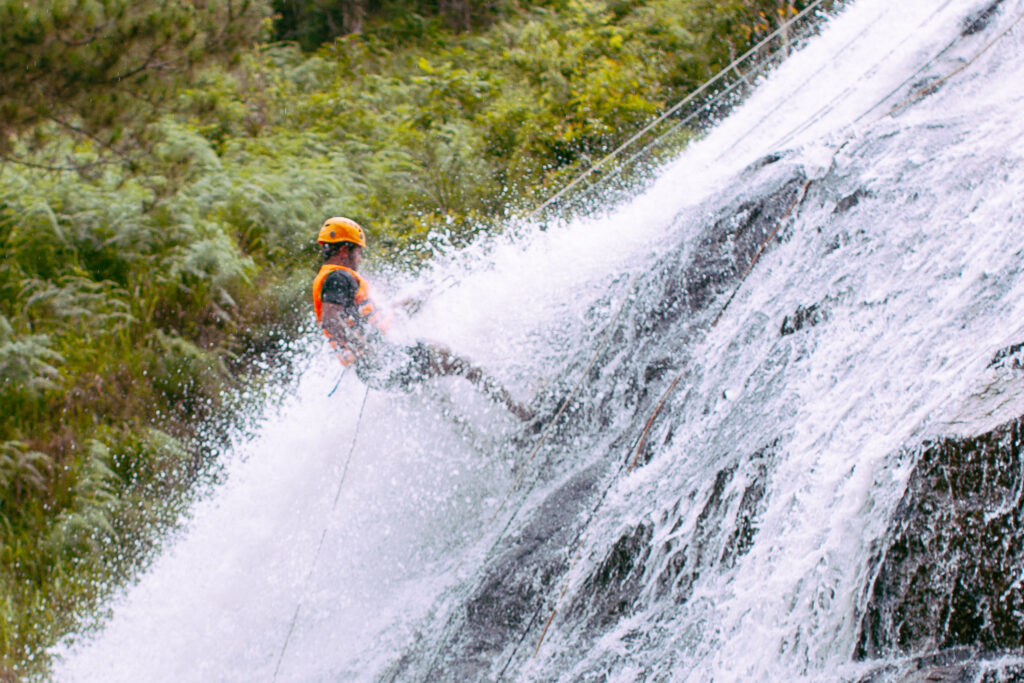 A man rappelling down a waterfall.