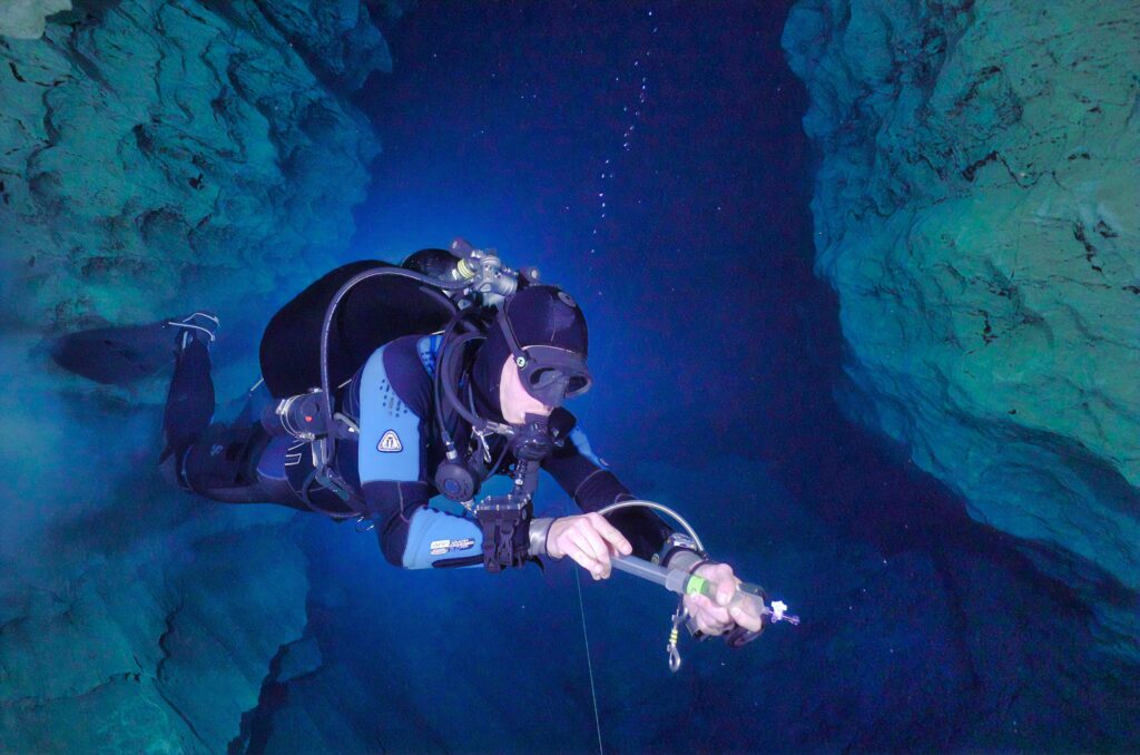 A man swims inside an underwater cavern.