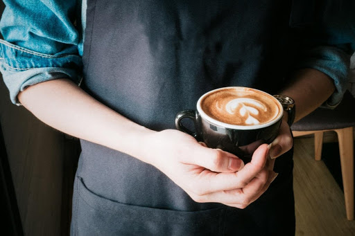 Barista holding a cup of coffee art