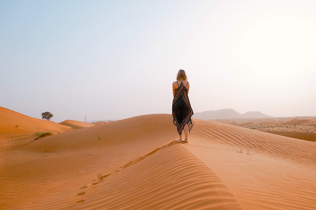 A female tourist strolling on the desert bare feet