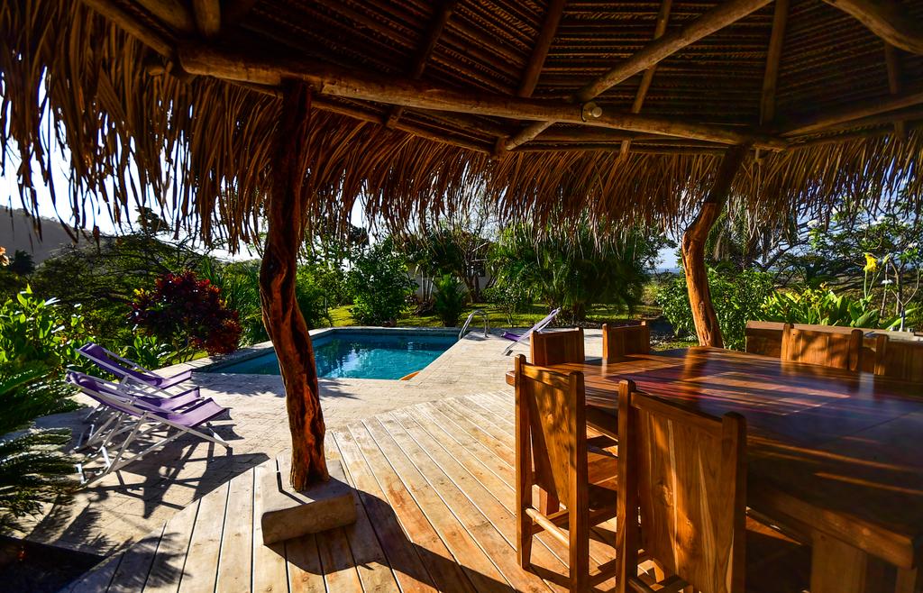 Garden of the Eden Resort lounging area with the outdoor pool