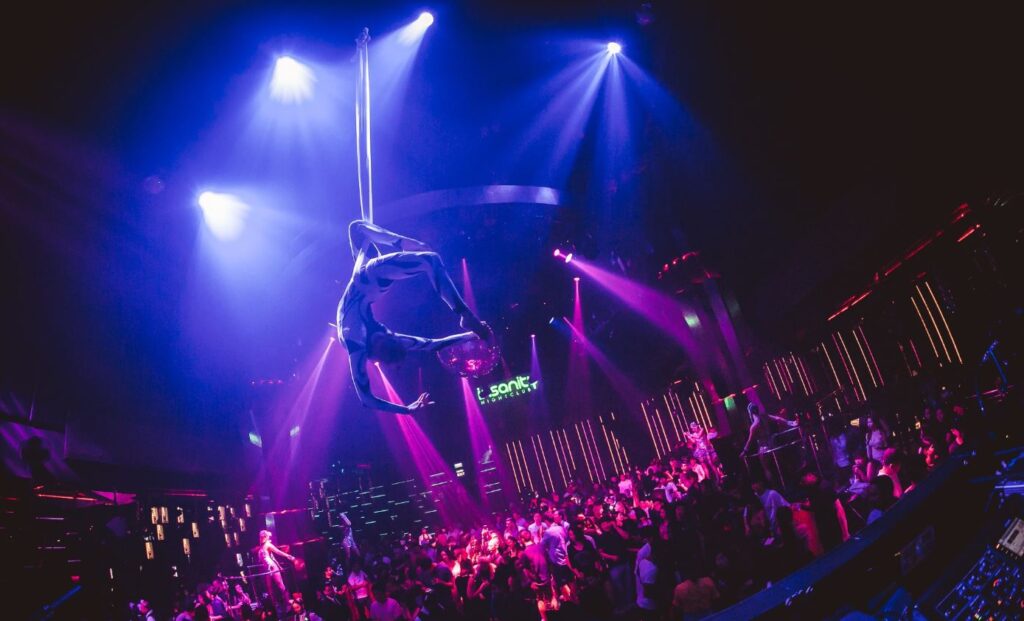 A person doing a aerial dance in a disco bar.