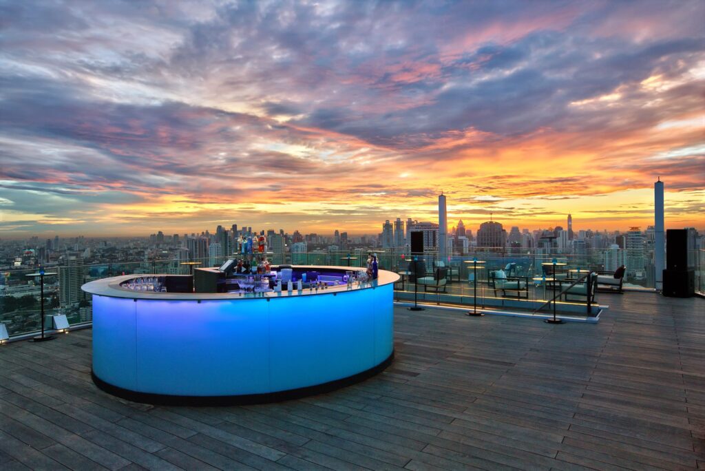 A bar balcony in a rooftop during sunset.