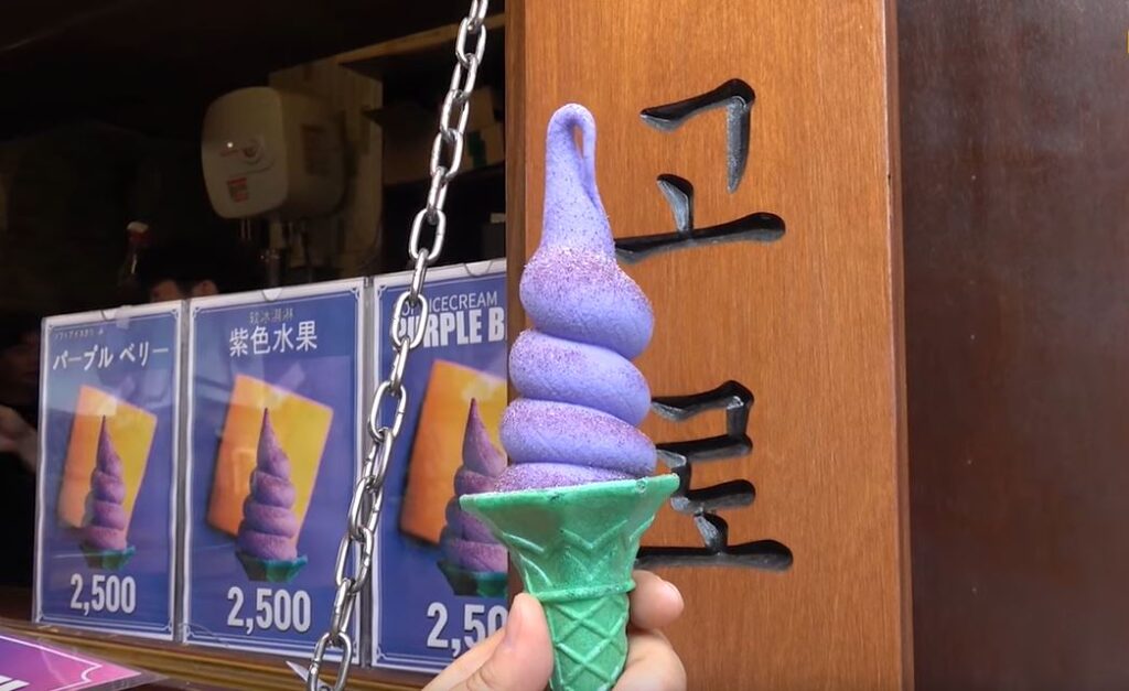 A purple soft serve on a green cone.