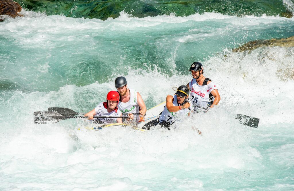 A group of 4 men riding a raft in a river.