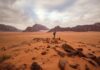 A guy traversing through the red sand desert in Jordan