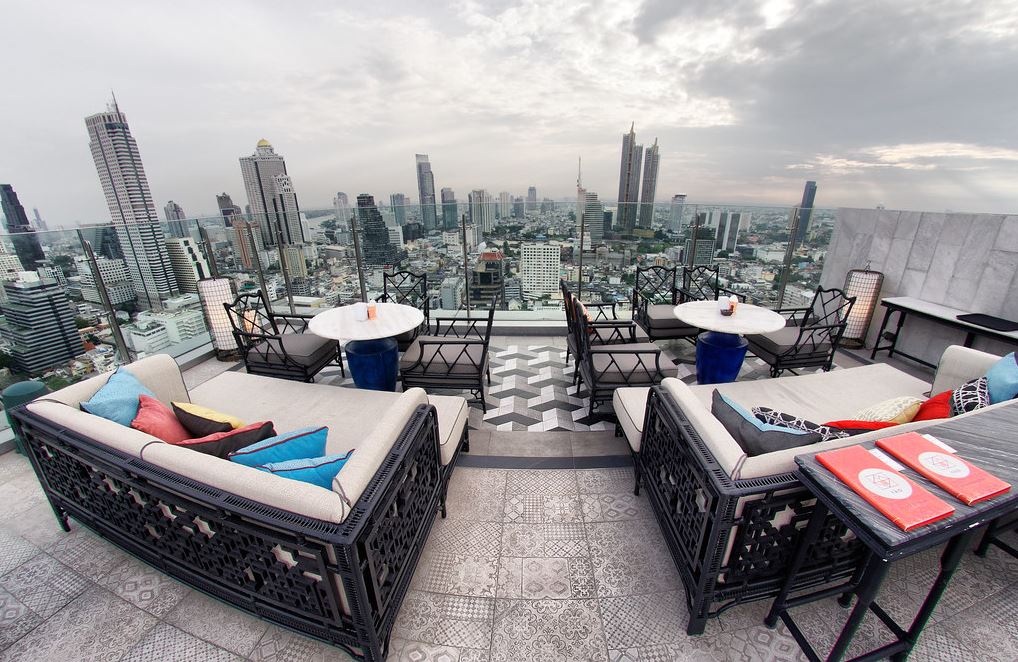 A lounge in a rooftop with two over-sized couch and cocktail tables.