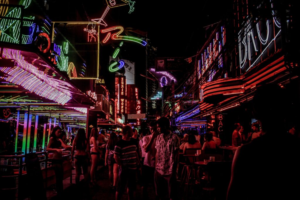 People standing between building full of lights.