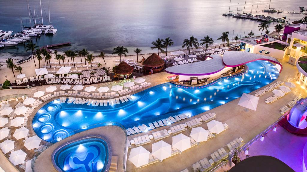 Temptation Cancun clothing optional resort with lighted pool in the evening