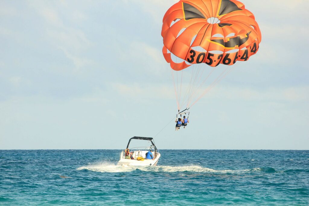 Two people riding a parachute towed by a speedboat.