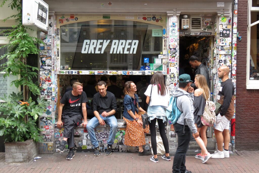 People in front of a shop with a signage that says "Grey Area"