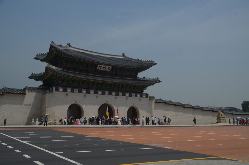 People outside the gate of a Korean traditional palace.