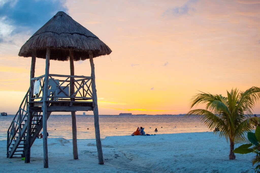 A hut by the seashore during sunset.