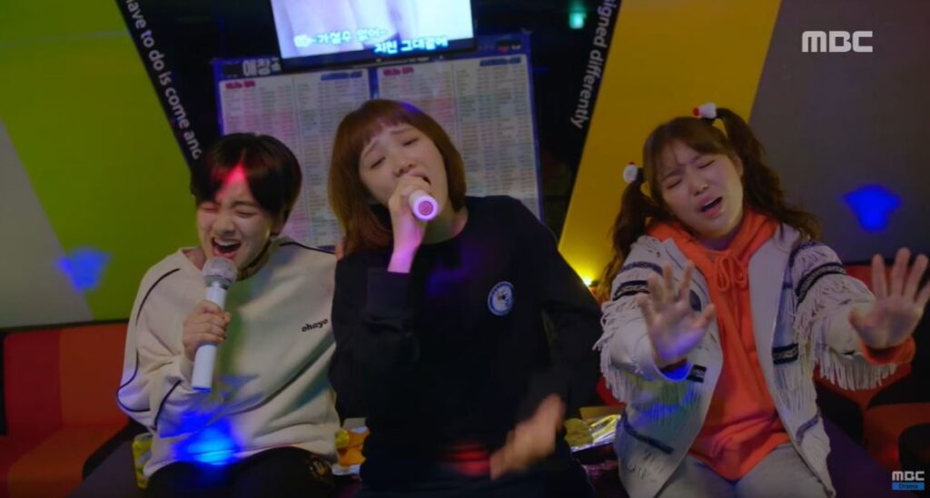 Three girls singing in a karaoke.