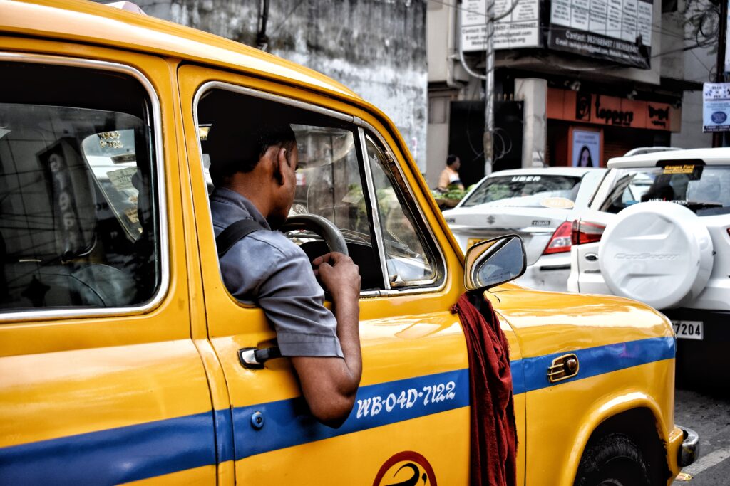 A man inside a yellow taxi.
