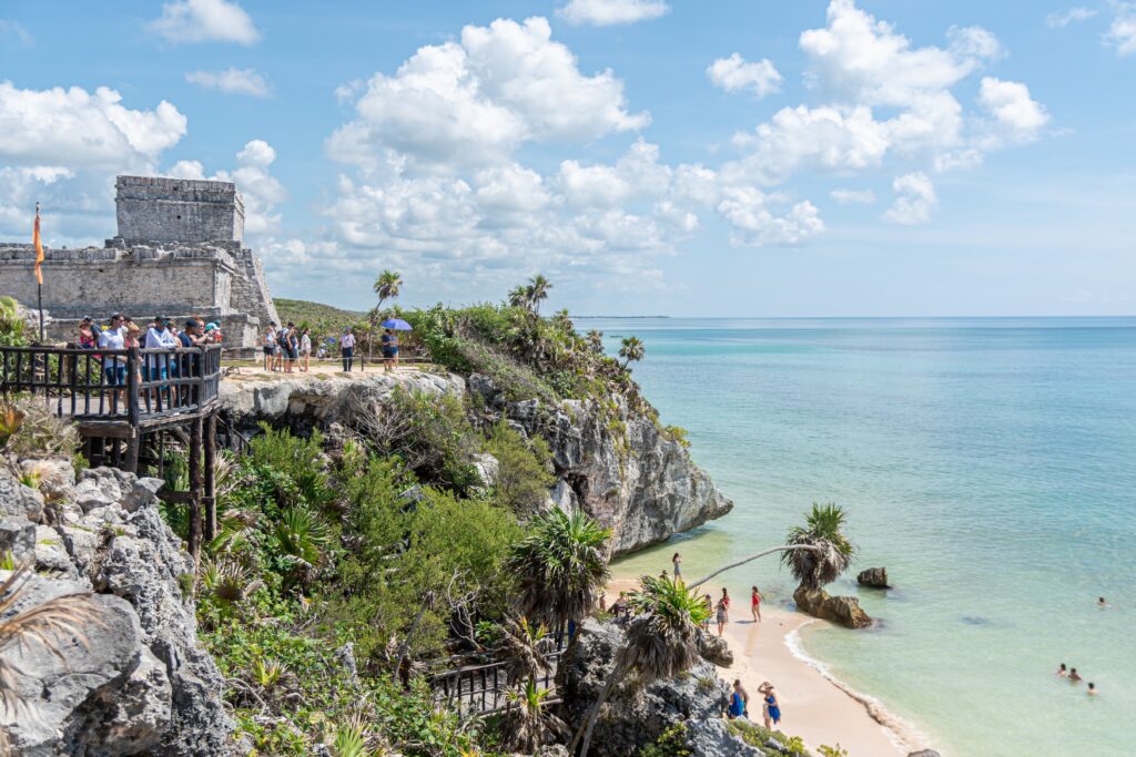 People standing on top of a cliff near the coast.