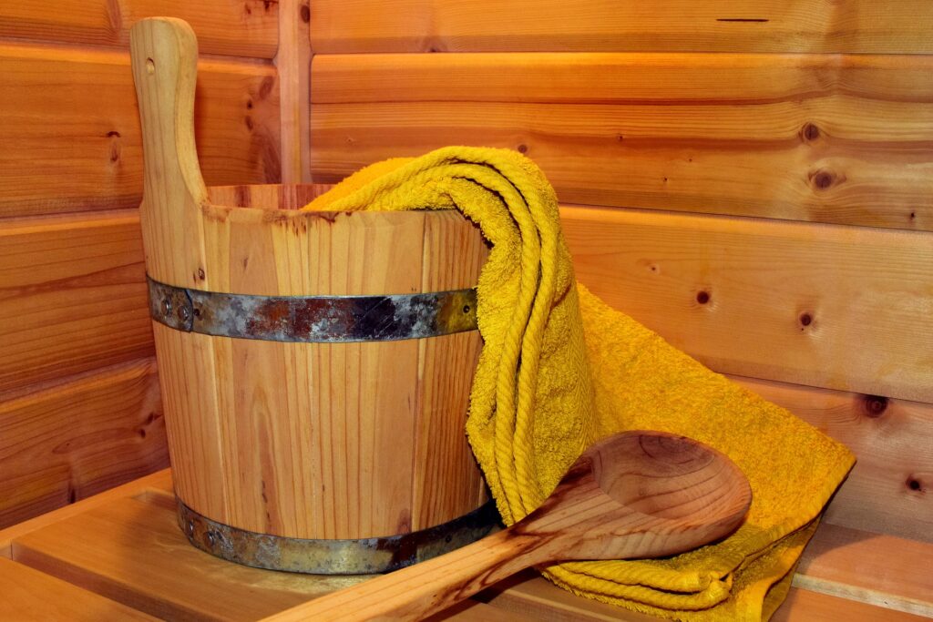 A wooden pail and water dipper in a sauna.